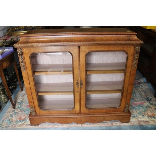 406 - A Victorian figured walnut gilt metal mounted low bookcase enclosed two glazed arch top doors, on bl... 