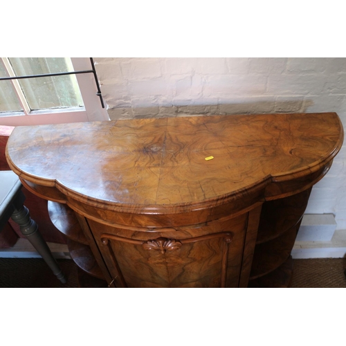 427 - A late Victorian figured walnut shape front credenza with open shelves and panel bowfront door, on b... 