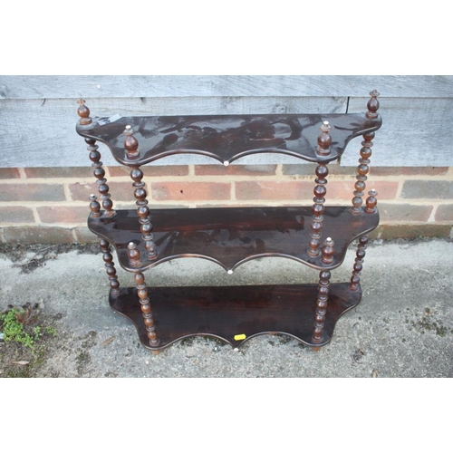 465 - A 19th century fruitwood serpentine front three-tier open wall shelf, with bobbin turned supports, 2... 