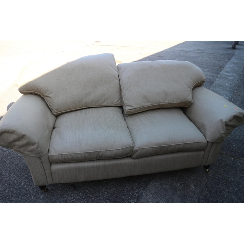 538 - A two-seat settee with splay arms and down loose seat and back cushions, on turned supports and bras... 