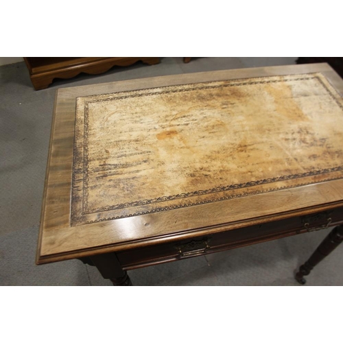 553 - An Edwardian walnut writing desk with tooled lined top, fitted one drawer, on turned and castored su... 