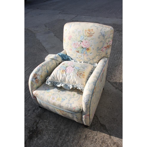 595 - A 1930s armchair with shaped arms, upholstered in a floral and scroll glazed chintz