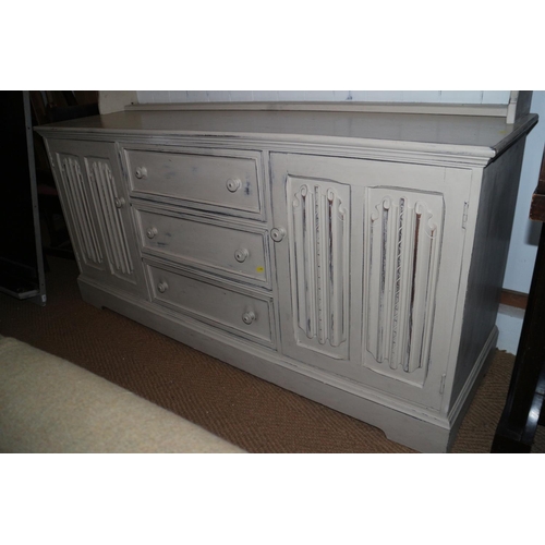 598 - A cream painted oak dresser, the upper section with galleried shelves and cupboards enclosed wire gr... 