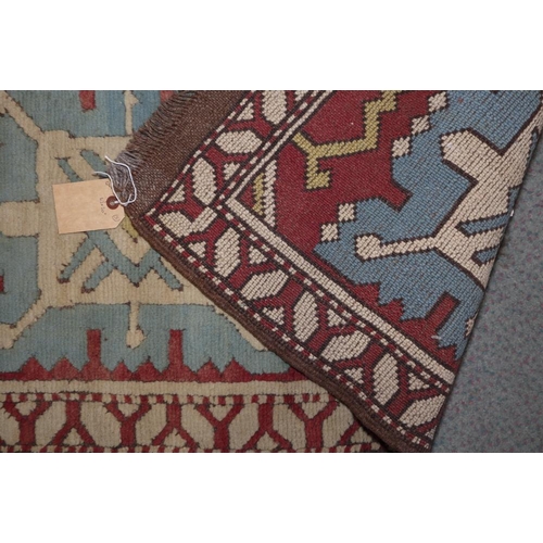 616 - A Kazak rug with two blue medallions on a red ground, 42