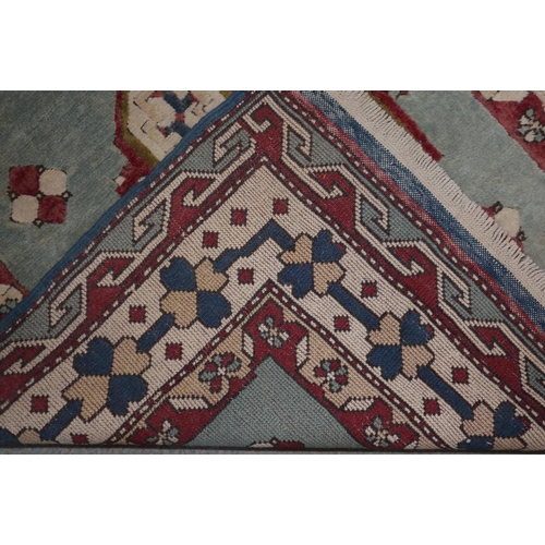 617 - A Kazak rug with two white cruciform guls on a light blue ground and multi-borders in shades of blue... 