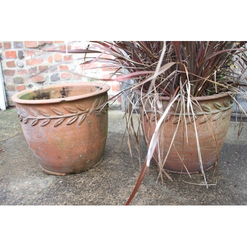 621 - A pair of terracotta plant pots with wheat relief decoration, 17 1/2