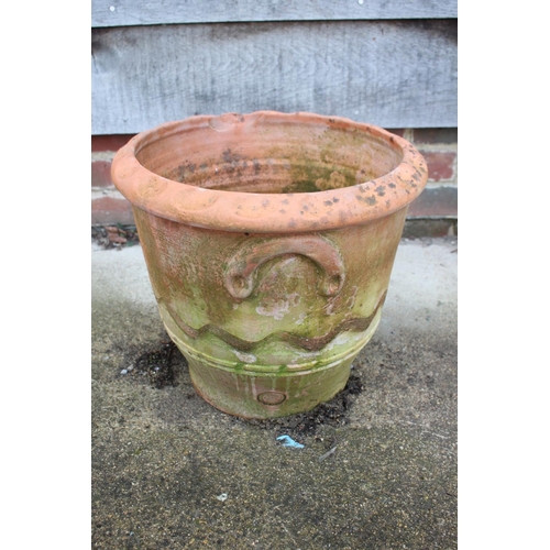 627 - A terracotta plant pot with undulated decoration and relief handles, 13 3/4