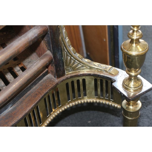 634 - A 19th century steel and brass fire grate of Adam design  with pierced apron, on turned tapered supp... 