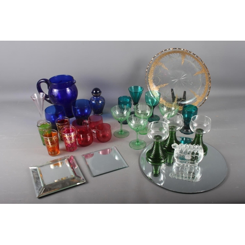 98 - A quantity of coloured glassware, including retro wines, cranberry glass mugs, a gilt decorated dish... 