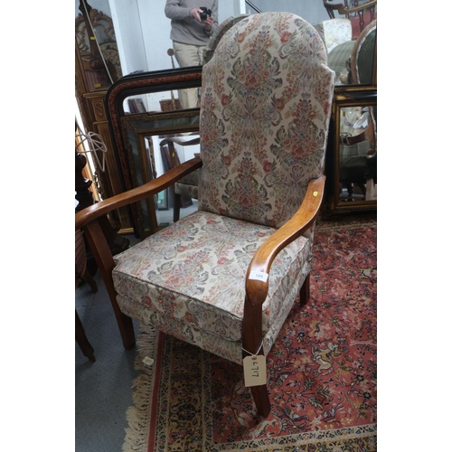 595 - A 1930s armchair with shaped arms, upholstered in a floral and scroll glazed chintz