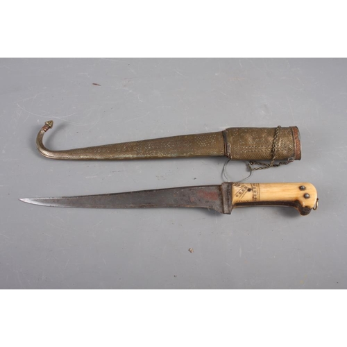 185 - An Indian dagger with steel blade and carved handle with engraved brass and copper scabbard, 18 1/2