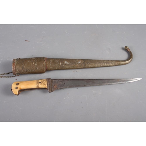 185 - An Indian dagger with steel blade and carved handle with engraved brass and copper scabbard, 18 1/2