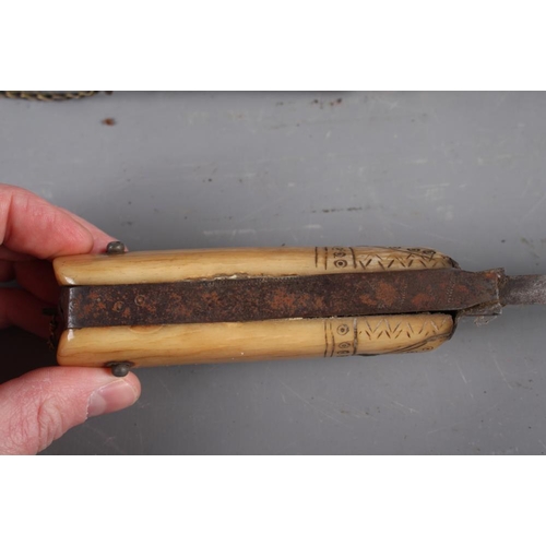 185 - An Indian dagger with steel blade and carved handle with engraved brass and copper scabbard, 18 1/2