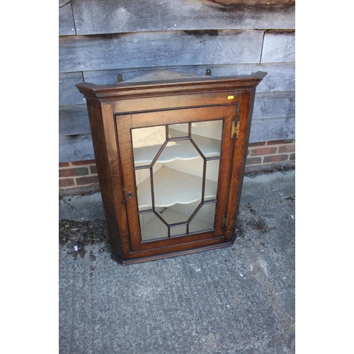 402 - An oak corner hanging cabinet enclosed astragal glazed door, 30