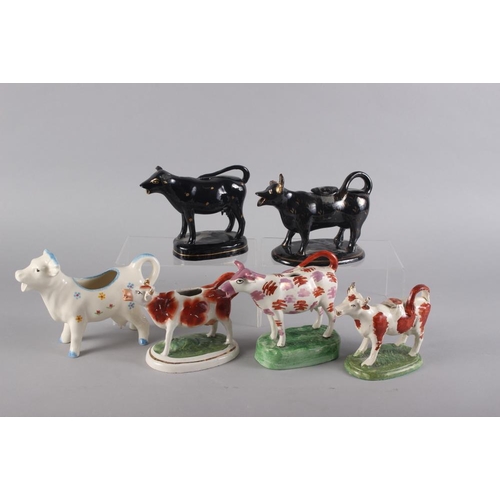 80 - Six 19th century and later model cow creamers, including a German cow creamer with floral decoration... 