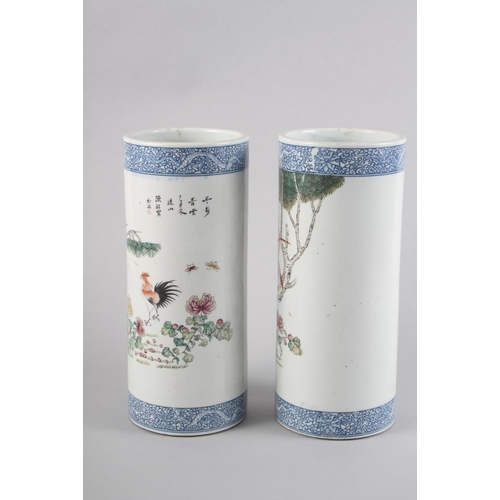 94 - A pair of Chinese cylindrical vases, decorated birds and trees with blue dragon borders, 11