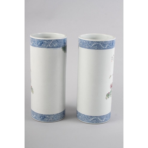 94 - A pair of Chinese cylindrical vases, decorated birds and trees with blue dragon borders, 11