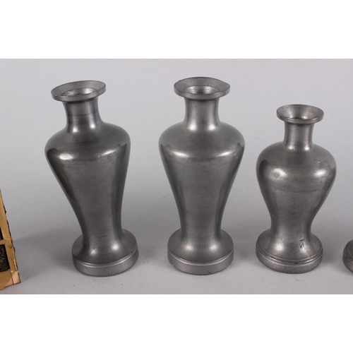 114 - Five Japanese pewter saki bottles/decanters and a lacquered miniature chest of four drawers, 4