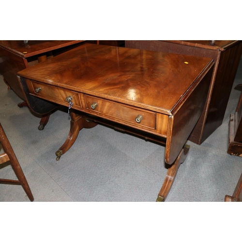 381 - A mahogany drop flap sofa table, fitted two drawers, on splayed and castored supports, 35