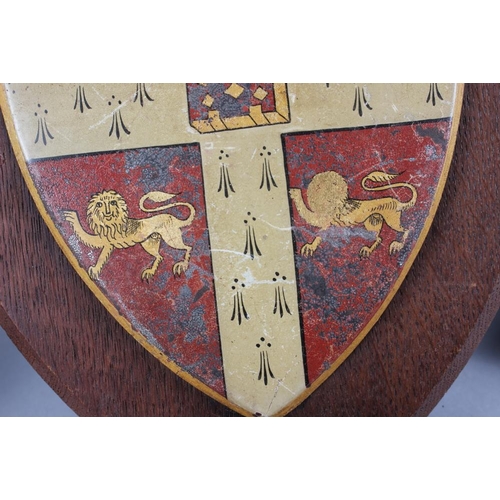 202 - Two painted metal coats of arms on easel stands, 12 1/2