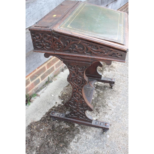 396 - A late 19th century oak fretwork slope top writing desk, on panel end supports, 21 1/2