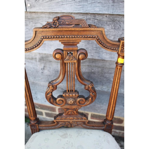 456 - A pair of Edwardian carved walnut salon chairs with lyre backs and stuffed over seats, on fluted sup... 