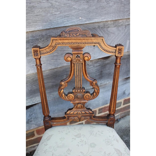 456 - A pair of Edwardian carved walnut salon chairs with lyre backs and stuffed over seats, on fluted sup... 