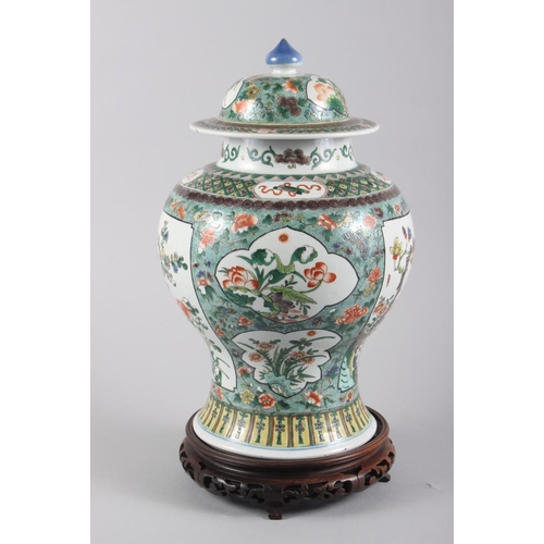 121 - A Chinese porcelain inverted baluster vase and cover, decorated in famille verte enamels, six charac... 