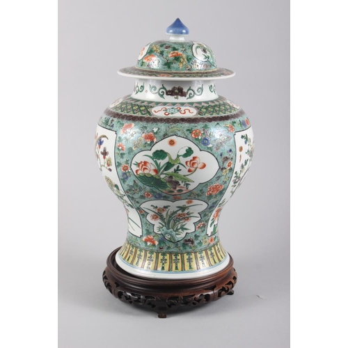 121 - A Chinese porcelain inverted baluster vase and cover, decorated in famille verte enamels, six charac... 