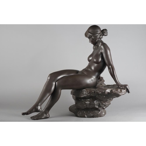 24 - A bronzed Lladro sculpture of a nude woman resting on a rock, base signed 