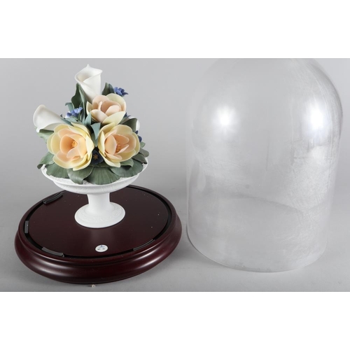 39 - A Lladro porcelain arrangement under a glass dome, 