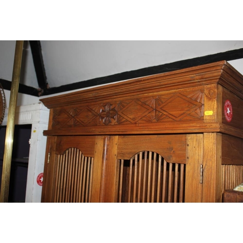 454 - An Indonesian teak cupboard enclosed two spindle decorated doors and drawer to base, 39