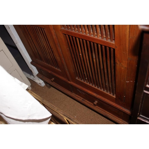 454 - An Indonesian teak cupboard enclosed two spindle decorated doors and drawer to base, 39