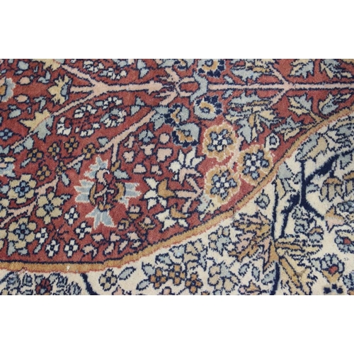 517 - A Kirman rug with all-over flower and tree design and central rust medallion, 72