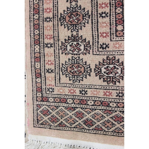 519 - A Bokhara rug of traditional design with thirty-three guls on a beige ground, 49