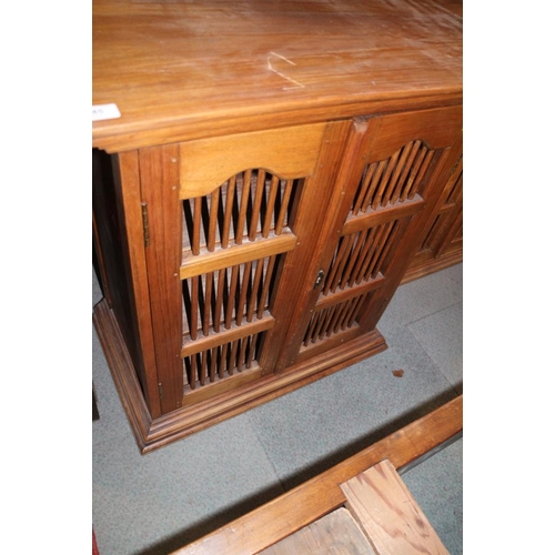 445 - An Indonesian teak cupboard enclosed two spindle decorated doors, 26