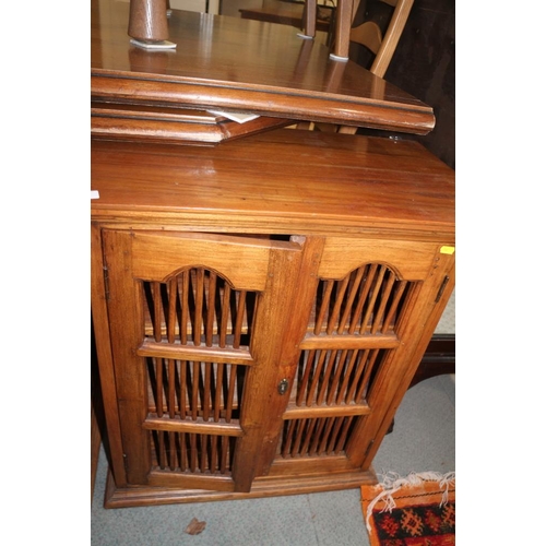 447 - An Indonesian teak cupboard enclosed two spindle decorated doors, 26