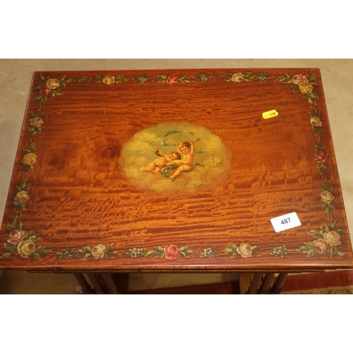 487 - A late 19th century satinwood nest of three tables, tops painted central cherub panel and floral bor... 