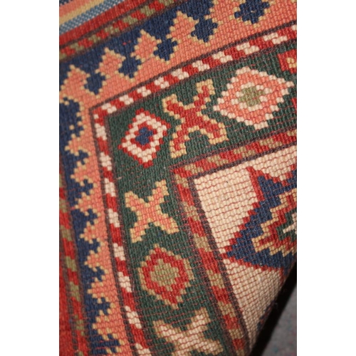 523 - A Caucasian pile rug with three central medallions, geometric designs and multi-borders in shades of... 