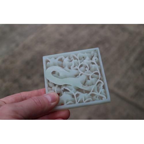 124 - A Chinese pale celadon jade plaque, decorated dragon and clouds, 2 7/8