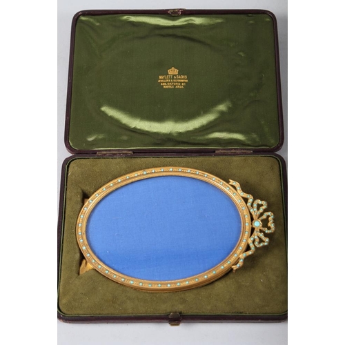 181 - A 19th century gilt metal oval shaped picture frame, inset turquoise with ribbon finial, supplied by... 