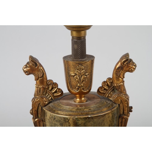 299 - A pair of gilt metal and anodised two-handled vase shaped table lamps, on circular bases with silk s... 