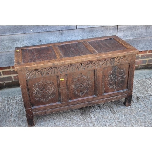 545 - An early 18th century oak carved coffer with triple panel front and 