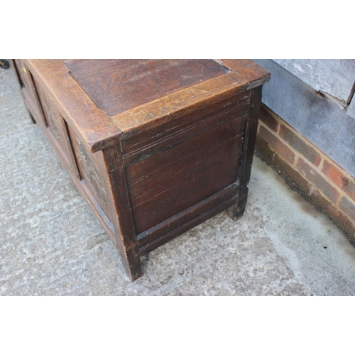 545 - An early 18th century oak carved coffer with triple panel front and 