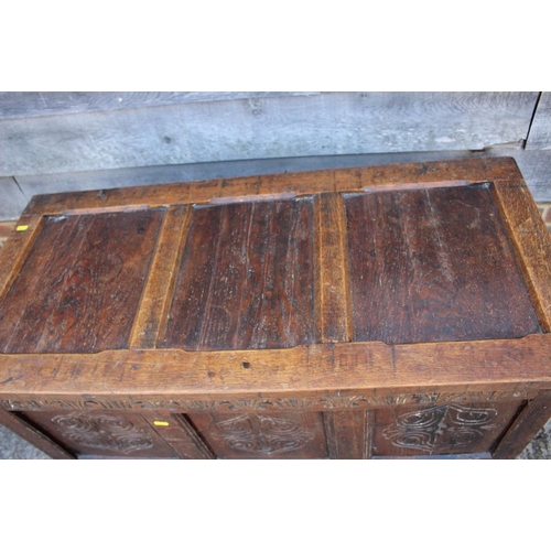 545 - An early 18th century oak carved coffer with triple panel front and 