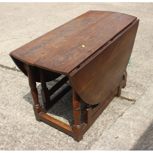 561 - A late Georgian oak oval gate leg dining table, on turned and stretchered supports, 42