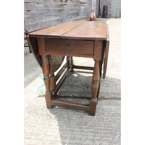 561 - A late Georgian oak oval gate leg dining table, on turned and stretchered supports, 42