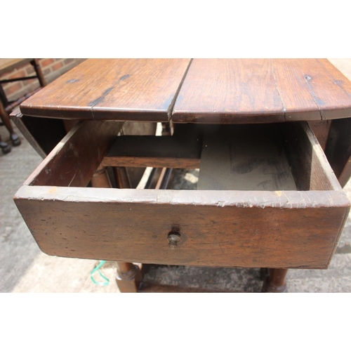 561 - A late Georgian oak oval gate leg dining table, on turned and stretchered supports, 42