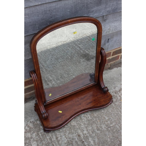 604 - A mahogany framed serpentine front swing frame mirror, on scroll supports, plate 23 1/4