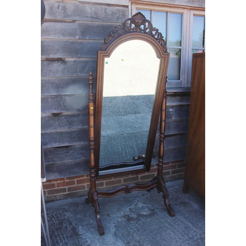 605 - A hardwood arch top cheval mirror with ornate carved finial, bevelled plate 53 3/4